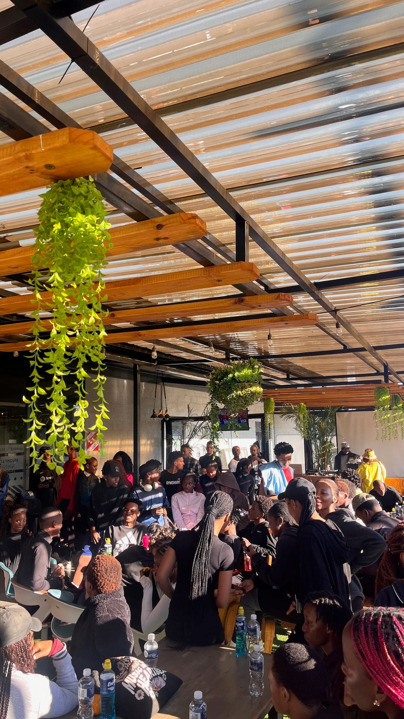 The community packed into the clubhouse interior under hanging plants