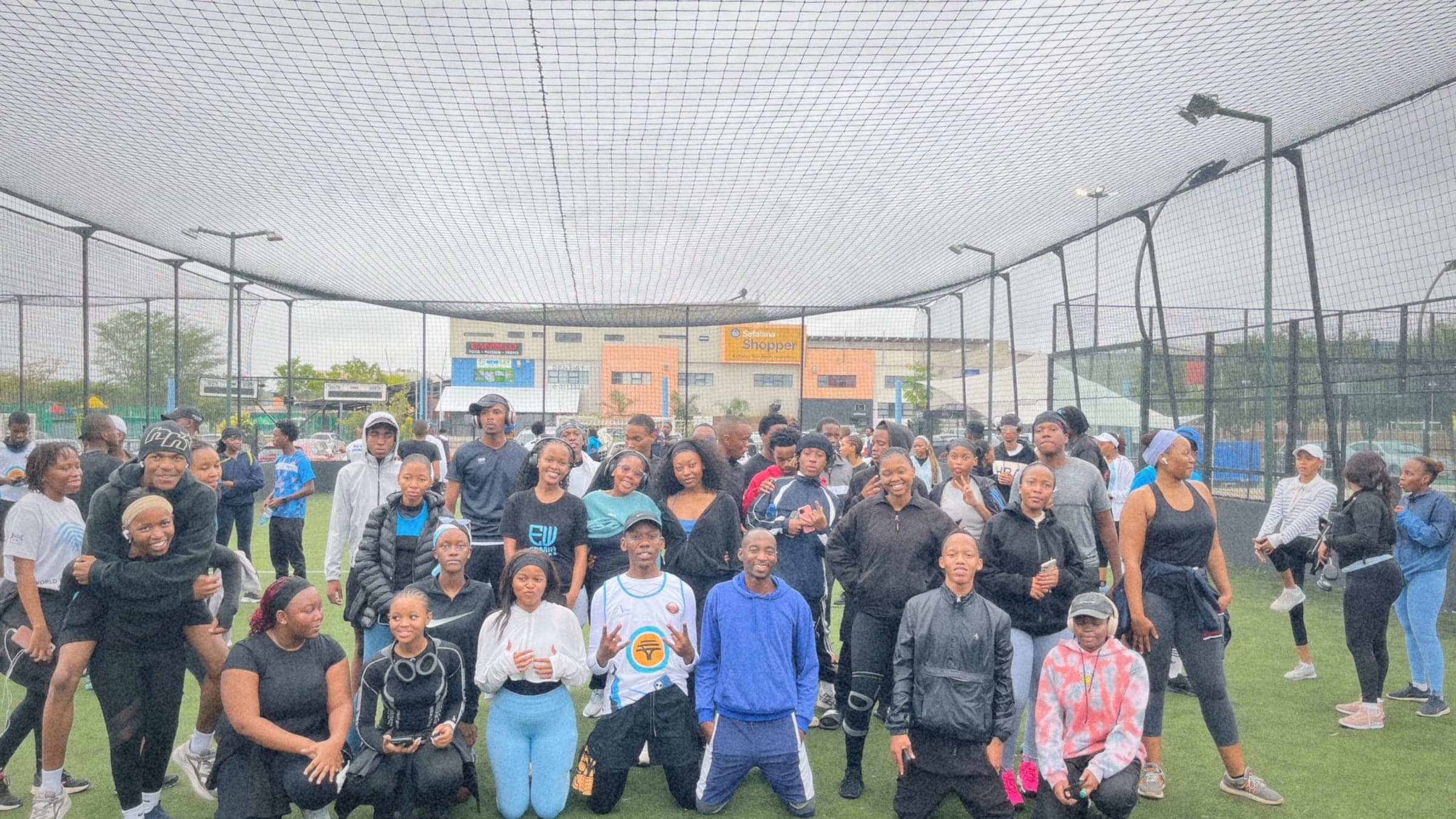 Wide group photo of the full Pace Day turnout on the turf pitch