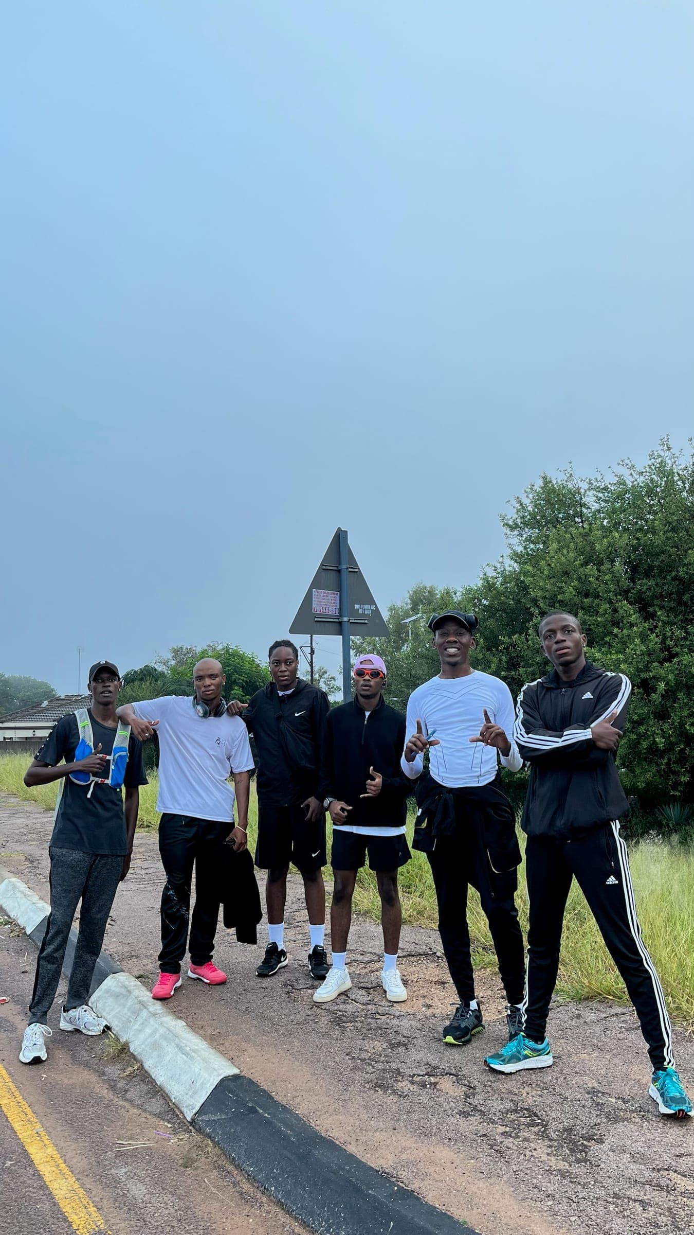 Six Pace Us runners posing on the roadside on an overcast morning