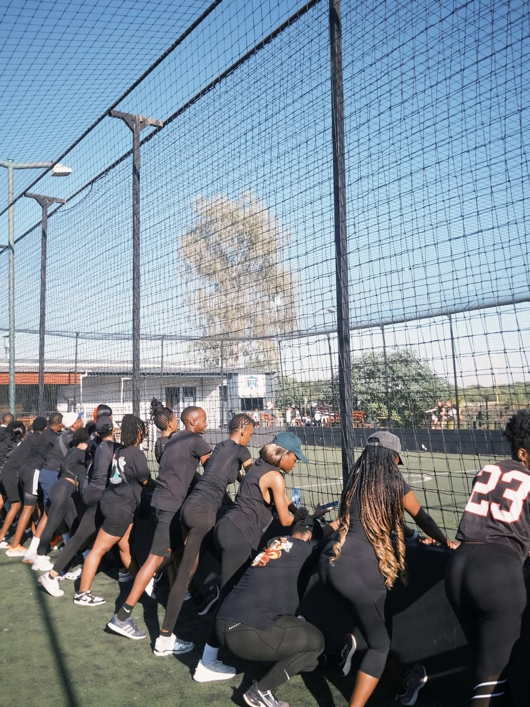 Group lunge stretch along the fence line before a run
